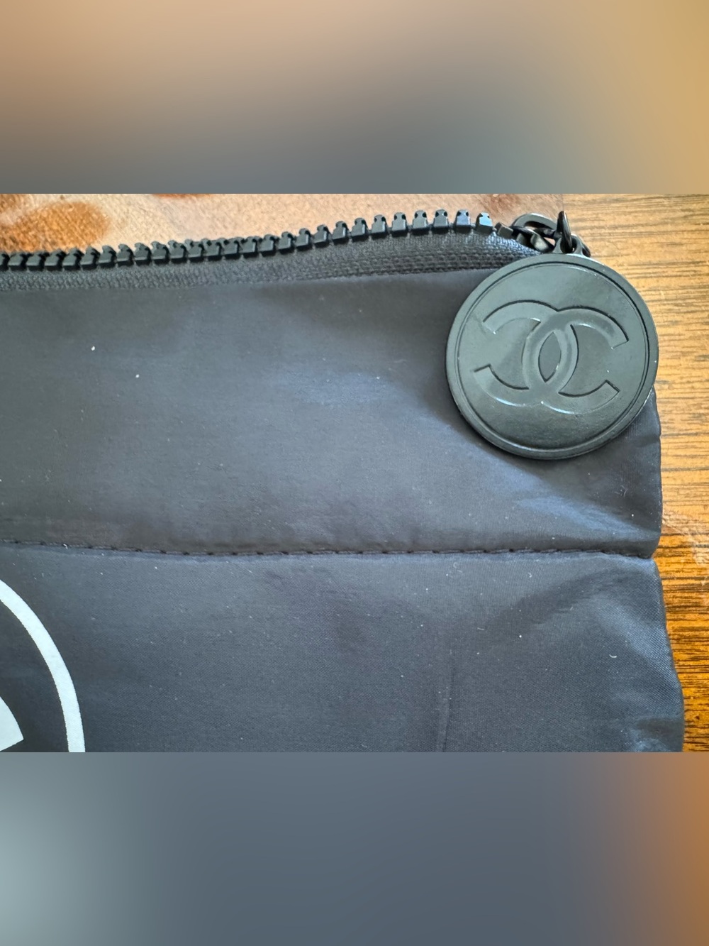 CHANEL Black cosmetic bag with White CC Emblem and a gold CC on the other side. - Picture 3 of 6